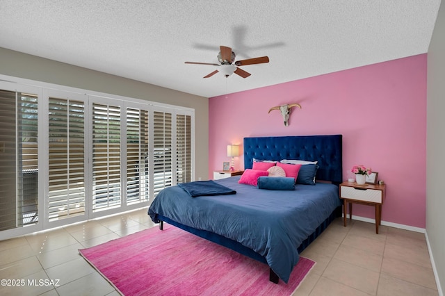 bedroom with ceiling fan, light tile patterned floors, and a textured ceiling