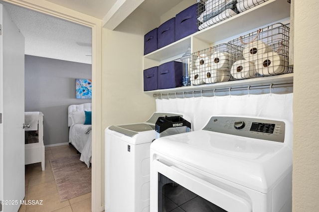 washroom with washing machine and clothes dryer and light tile patterned flooring