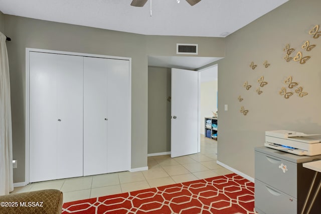 interior space with ceiling fan, a closet, and light tile patterned flooring