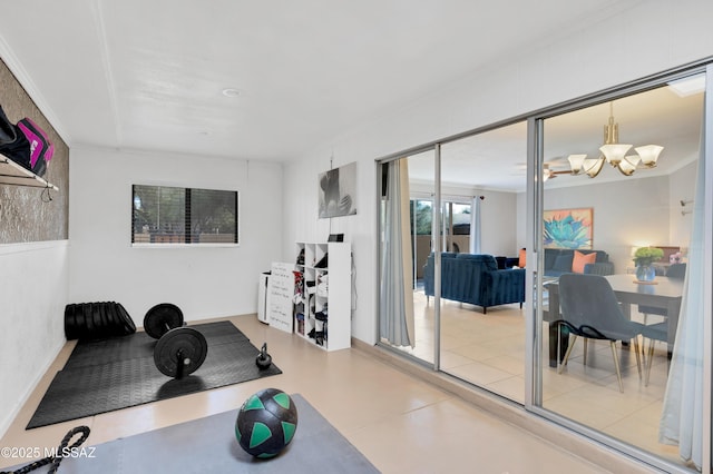 workout area with ornamental molding and a chandelier