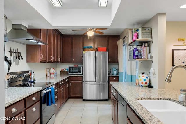 kitchen featuring sink, ceiling fan, light stone countertops, appliances with stainless steel finishes, and light tile patterned flooring