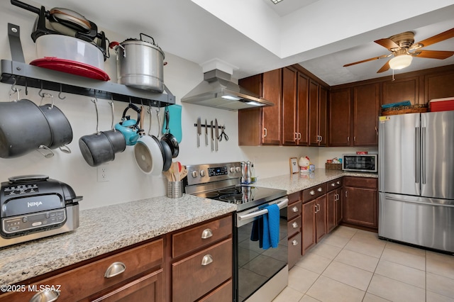 kitchen with light stone countertops, ceiling fan, stainless steel appliances, ventilation hood, and light tile patterned floors