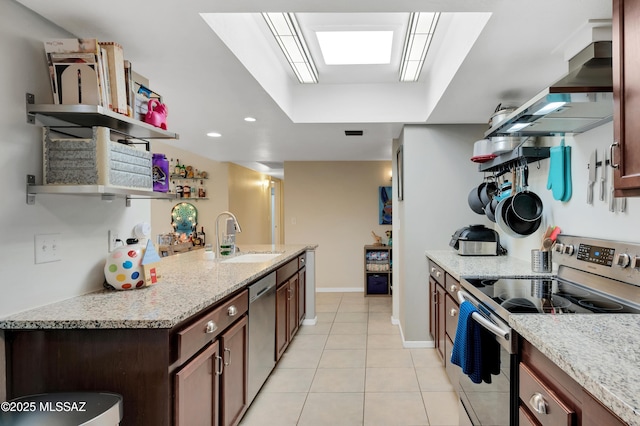 kitchen featuring light stone countertops, sink, stainless steel appliances, wall chimney range hood, and light tile patterned flooring