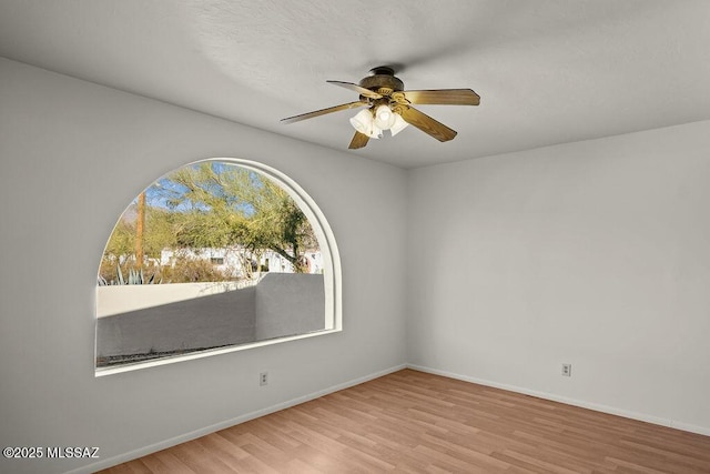 unfurnished room with ceiling fan and light wood-type flooring