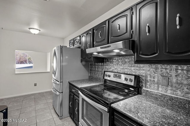 kitchen featuring light tile patterned floors, stainless steel appliances, tasteful backsplash, and dark stone counters