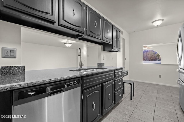 kitchen with stainless steel dishwasher, light tile patterned flooring, sink, and stone counters