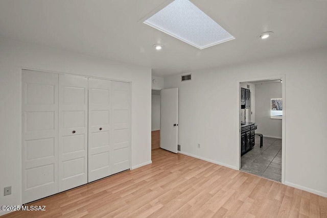 unfurnished bedroom featuring light hardwood / wood-style floors and a closet