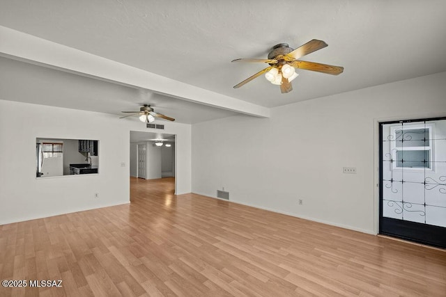 unfurnished living room with beam ceiling, light hardwood / wood-style flooring, and ceiling fan