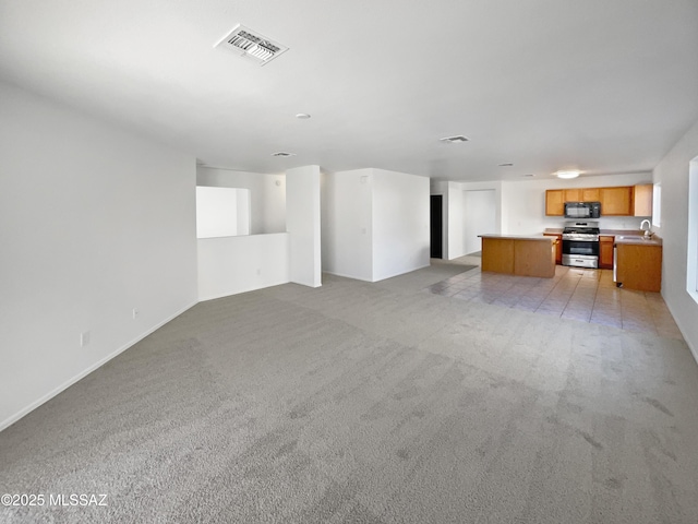 unfurnished living room featuring light colored carpet and sink