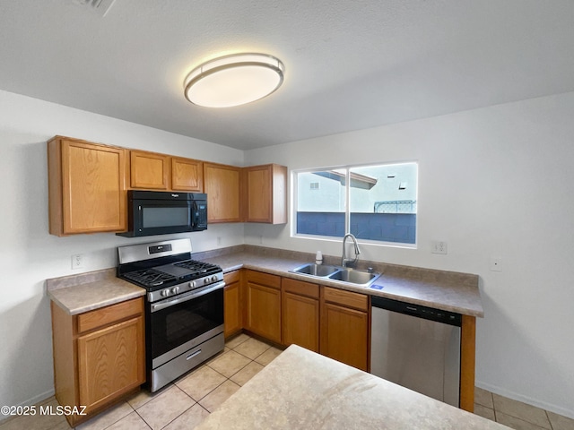 kitchen featuring appliances with stainless steel finishes, light tile patterned floors, and sink