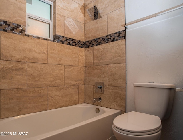 bathroom with toilet and tiled shower / bath