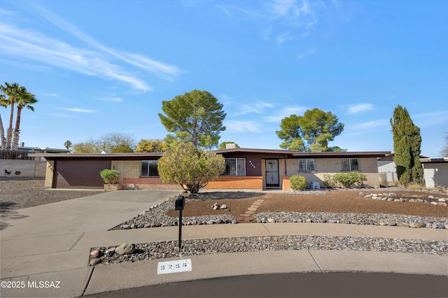 view of front of house featuring concrete driveway and brick siding