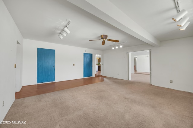 carpeted empty room with ceiling fan, track lighting, and beamed ceiling