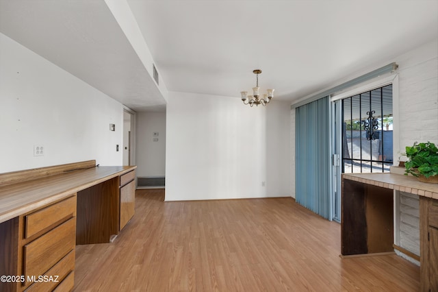 kitchen with pendant lighting, a chandelier, and light hardwood / wood-style floors