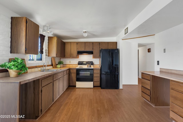 kitchen with sink, light wood-type flooring, white electric stove, and black fridge