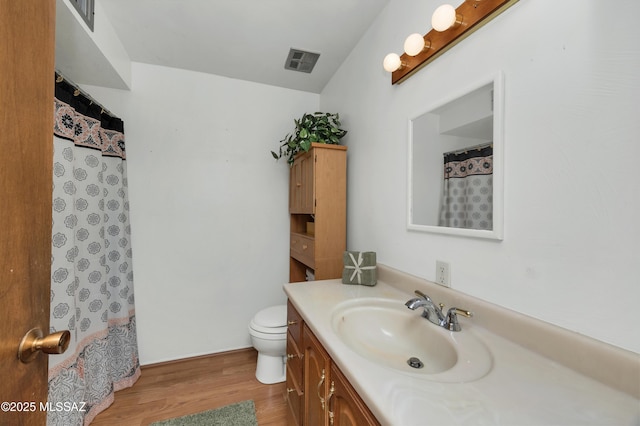 bathroom featuring vanity, hardwood / wood-style flooring, and toilet