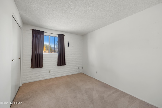 carpeted spare room with a textured ceiling