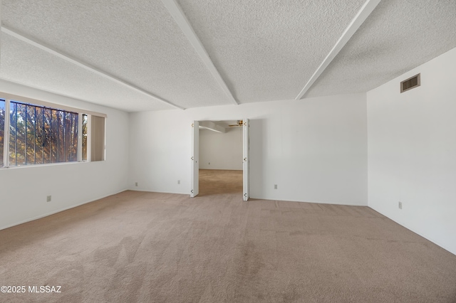 spare room featuring a textured ceiling, carpet floors, and ceiling fan