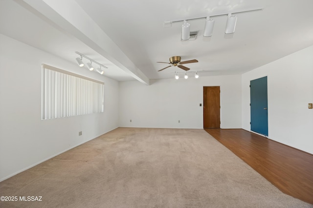 carpeted empty room featuring ceiling fan and rail lighting