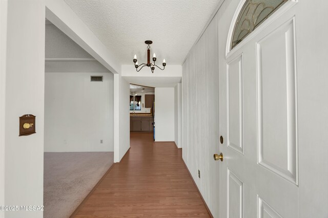 9256 E 26th St, Tucson, AZ 85710 - corridor with a chandelier, a textured ceiling, and wood finished floors