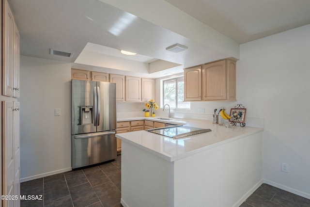 kitchen featuring sink, a raised ceiling, stainless steel fridge with ice dispenser, kitchen peninsula, and light brown cabinets