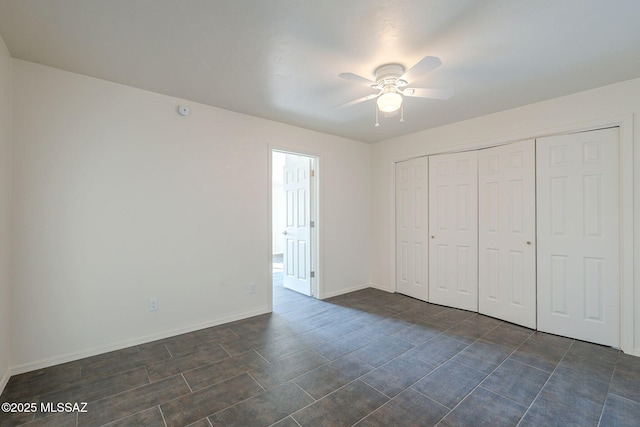 unfurnished bedroom featuring ceiling fan and a closet