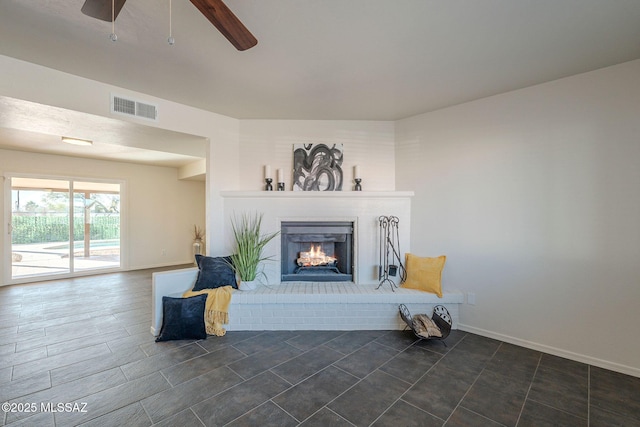 living room featuring a brick fireplace and ceiling fan