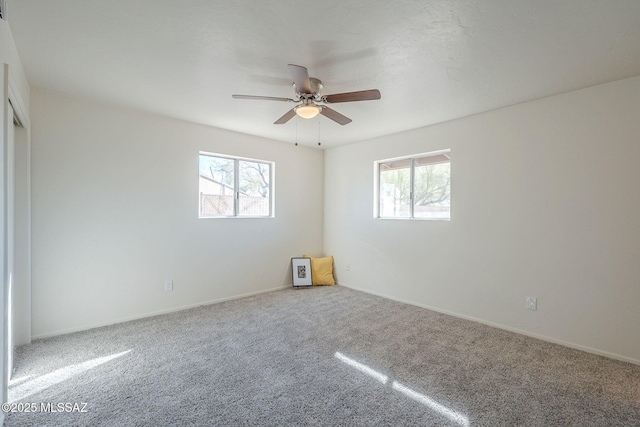 unfurnished room with carpet, a healthy amount of sunlight, and ceiling fan