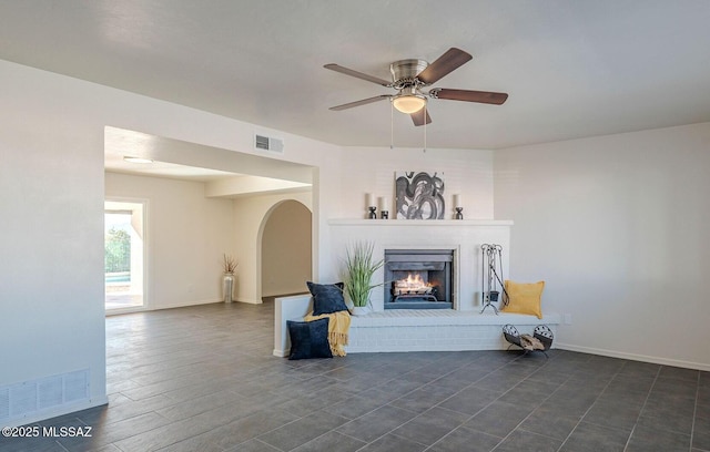 living room with a fireplace and ceiling fan