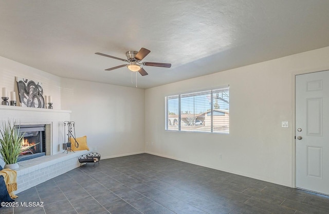 unfurnished living room with a fireplace and ceiling fan