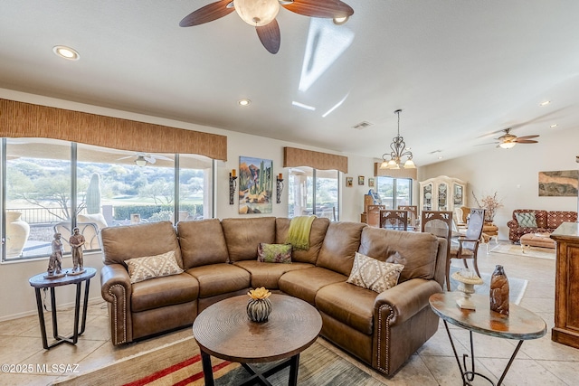 tiled living room with ceiling fan with notable chandelier and vaulted ceiling