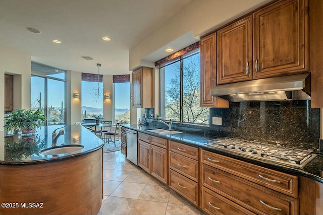 kitchen featuring sink, extractor fan, pendant lighting, and appliances with stainless steel finishes