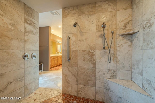 bathroom featuring a tile shower and vanity