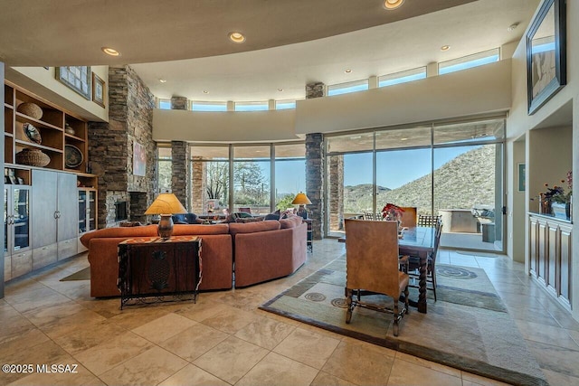 living room featuring a towering ceiling, built in features, and a mountain view