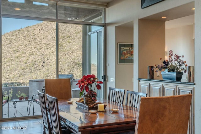 tiled dining room featuring a wall of windows