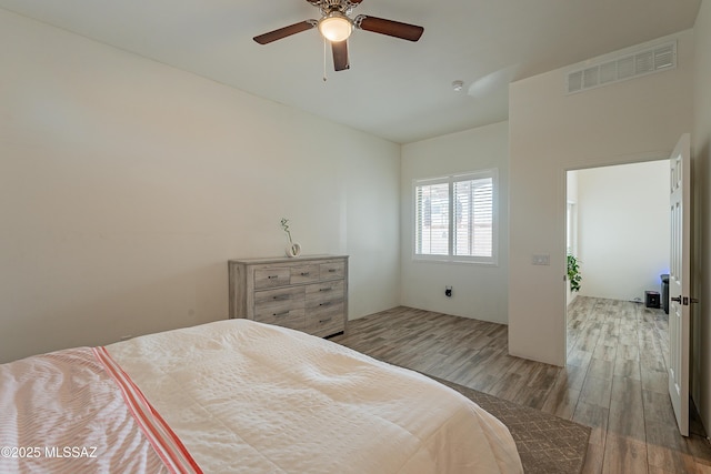 bedroom with visible vents, ceiling fan, and wood finished floors