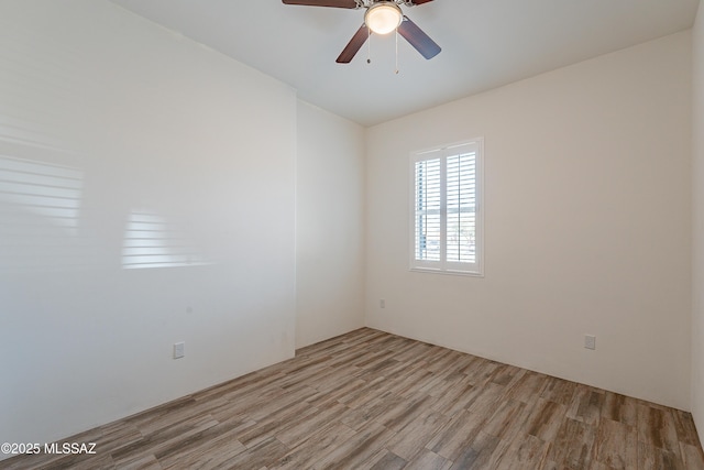 empty room with a ceiling fan and light wood-style floors