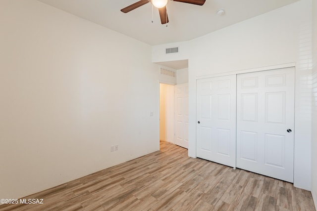 unfurnished bedroom with ceiling fan, light hardwood / wood-style floors, and a closet