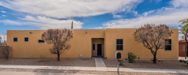 pueblo-style home featuring stucco siding