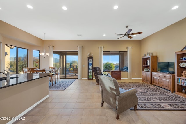 living room featuring sink, ceiling fan with notable chandelier, and light tile patterned floors