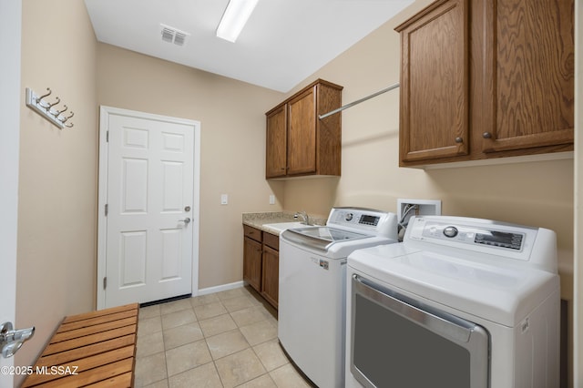 laundry area featuring cabinets, sink, washer and dryer, and light tile patterned flooring