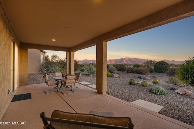 patio terrace at dusk featuring a mountain view