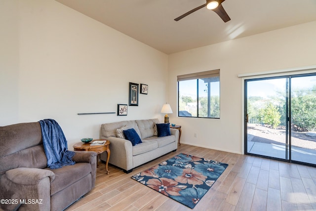 living room with light hardwood / wood-style flooring and ceiling fan