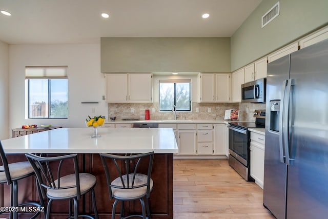 kitchen with sink, tasteful backsplash, white cabinetry, and appliances with stainless steel finishes