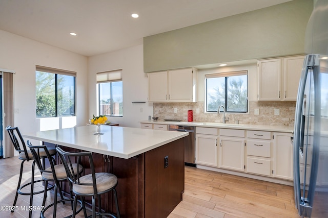 kitchen with sink, white cabinets, a center island, and appliances with stainless steel finishes