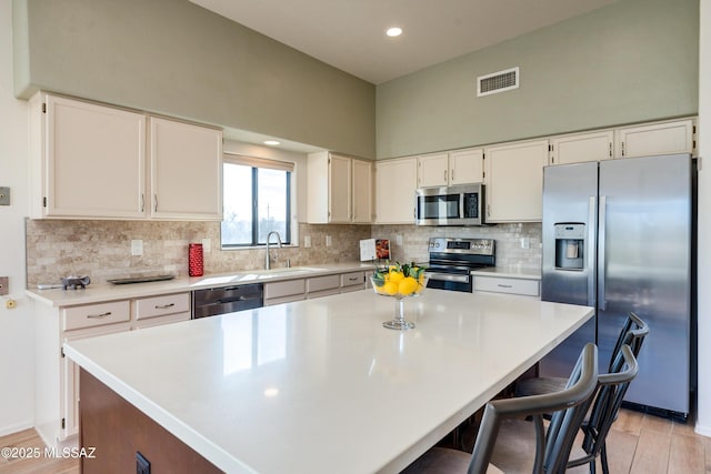 kitchen with sink, white cabinetry, appliances with stainless steel finishes, and a center island