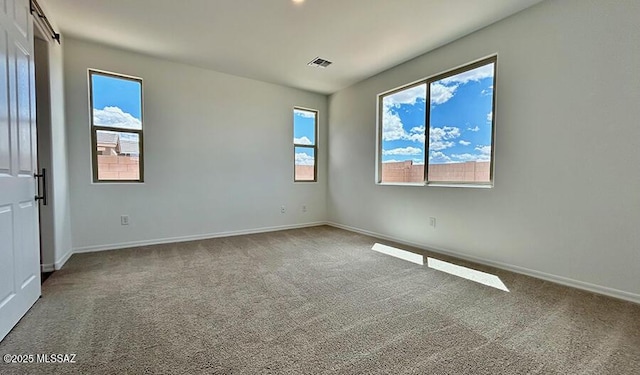spare room featuring baseboards, carpet flooring, and visible vents