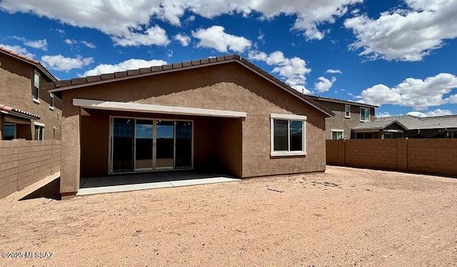 rear view of house featuring a patio area, a fenced backyard, and stucco siding
