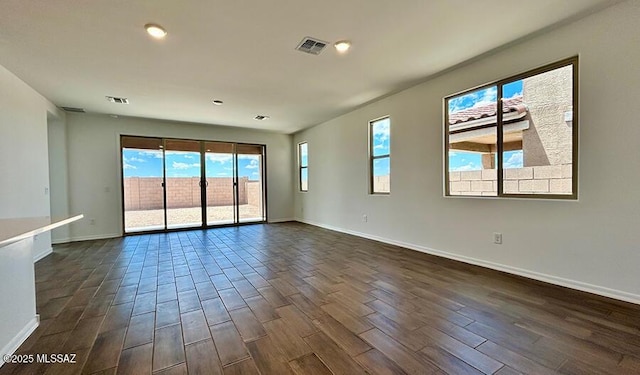 unfurnished room featuring dark wood-style floors, baseboards, and visible vents