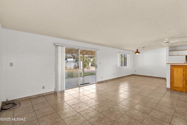 tiled spare room featuring ceiling fan and a textured ceiling